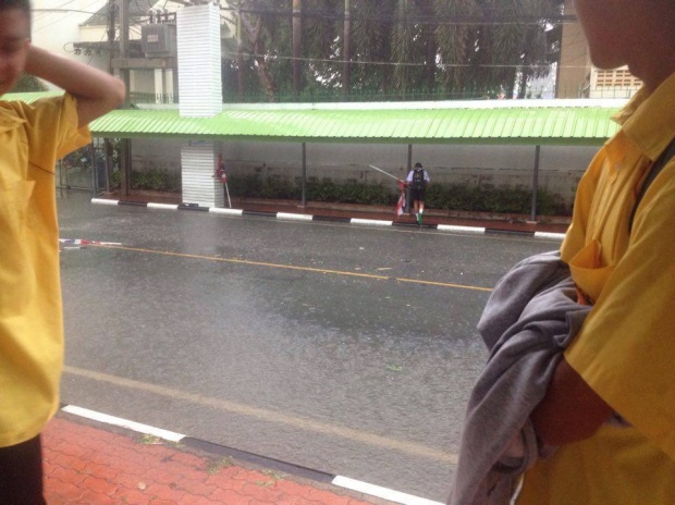ภาพน่าชื่นชม หนุ่มน้อยในชุดนักเรียน วิ่งฝ่าสายฝนเก็บธงชาติกลางถนน